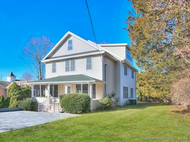 back of property with a yard and central AC unit