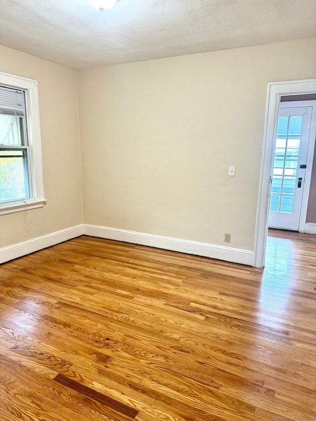 empty room featuring a textured ceiling and light wood-type flooring