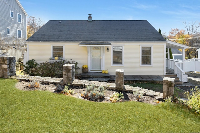 rear view of house featuring a lawn