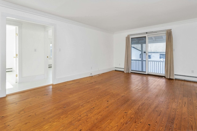 spare room featuring a baseboard heating unit, hardwood / wood-style flooring, and ornamental molding