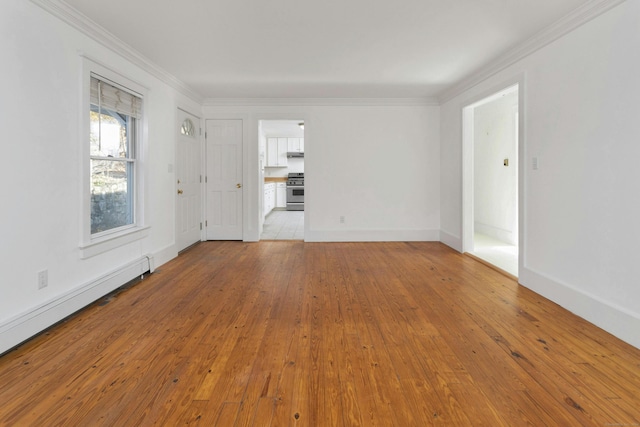 spare room featuring ornamental molding, light wood-type flooring, and a baseboard heating unit