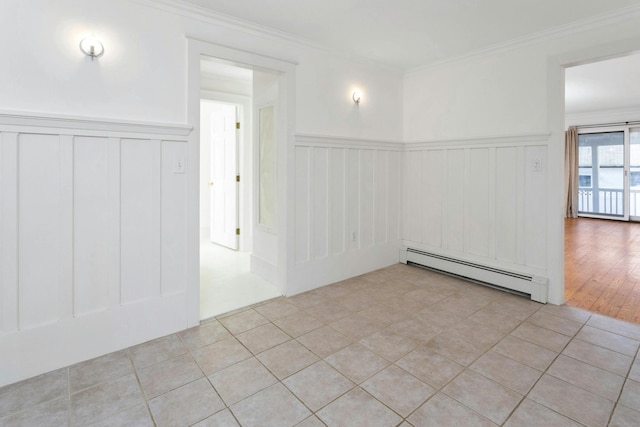 empty room featuring crown molding, light hardwood / wood-style floors, and a baseboard heating unit