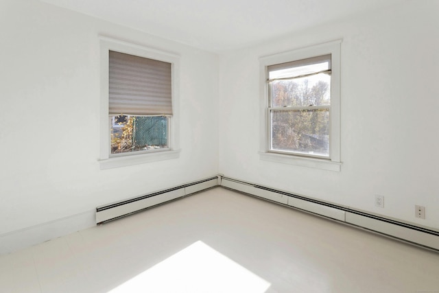 empty room with a baseboard heating unit and plenty of natural light