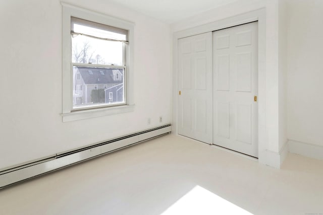 unfurnished bedroom with a closet and baseboard heating