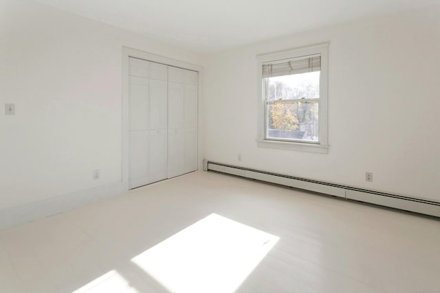 unfurnished bedroom featuring a baseboard radiator and a closet