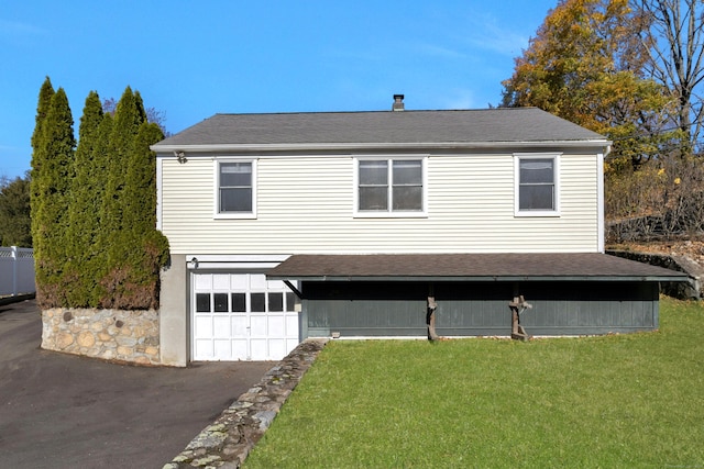 view of front of property featuring a garage and a front lawn