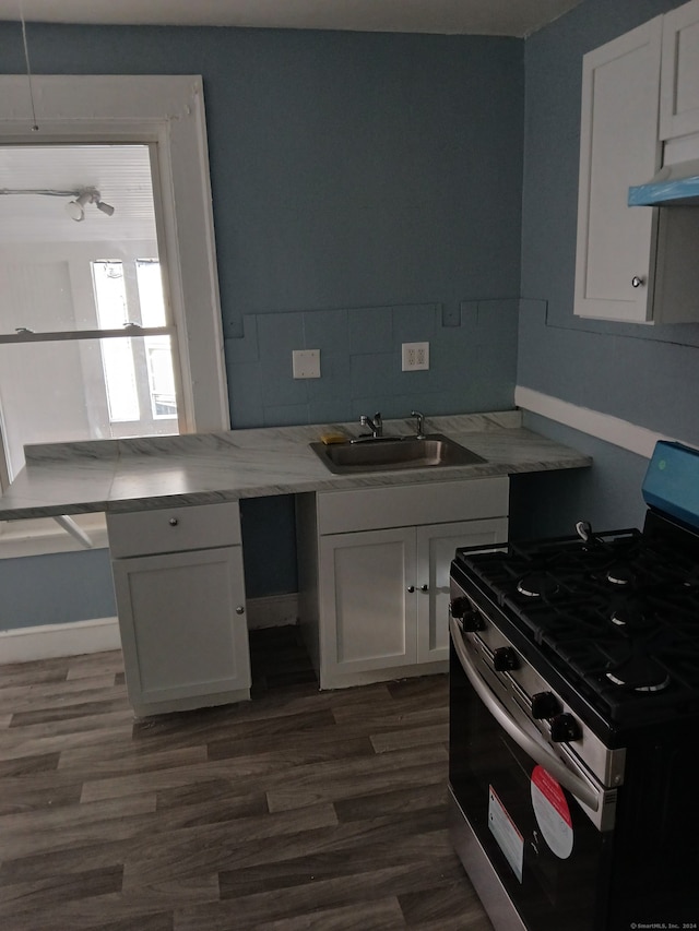 kitchen with stainless steel gas range, white cabinetry, sink, and dark hardwood / wood-style flooring