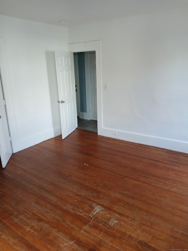 unfurnished room featuring dark wood-type flooring