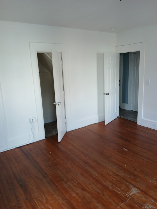 empty room with dark hardwood / wood-style flooring