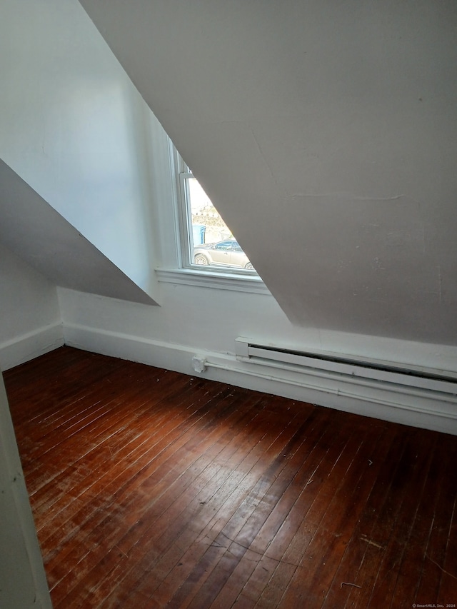 bonus room with a baseboard heating unit and dark hardwood / wood-style flooring