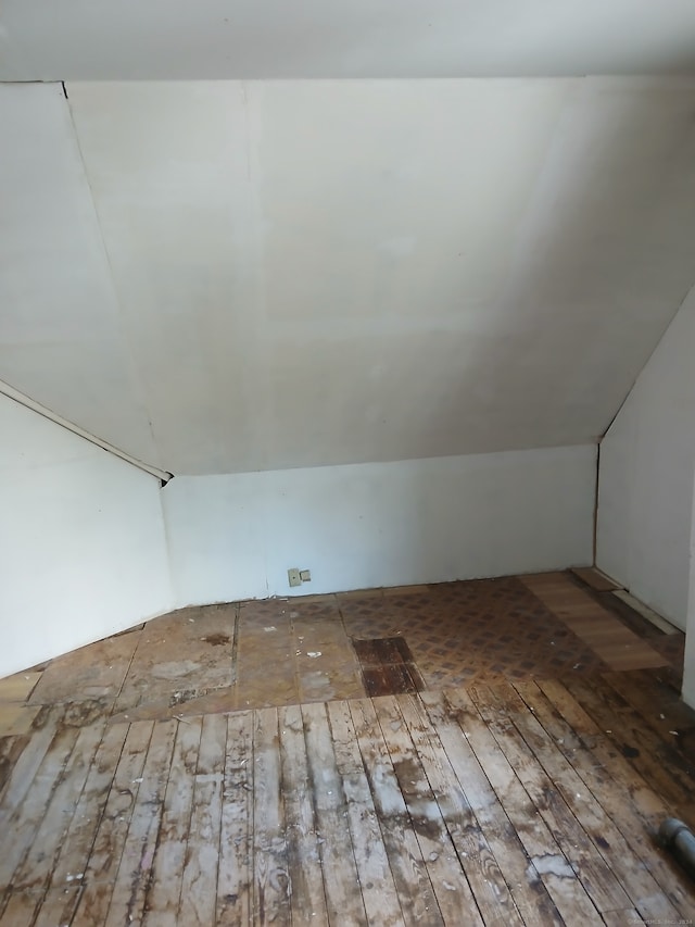 additional living space featuring wood-type flooring and vaulted ceiling