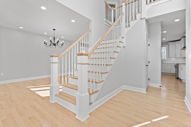 stairway featuring hardwood / wood-style flooring and a notable chandelier