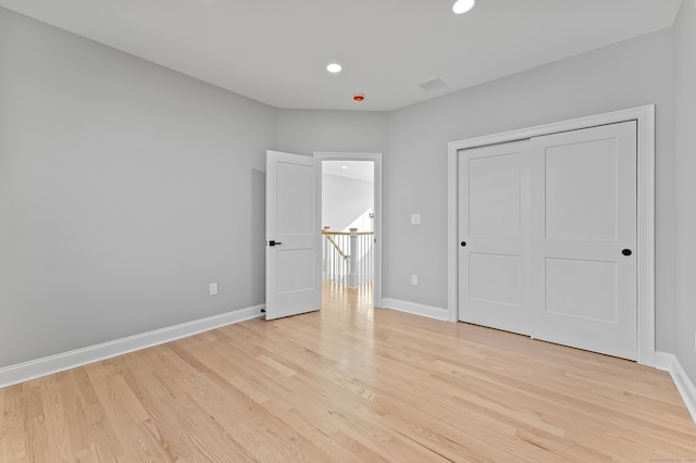 unfurnished bedroom featuring light wood-type flooring and a closet