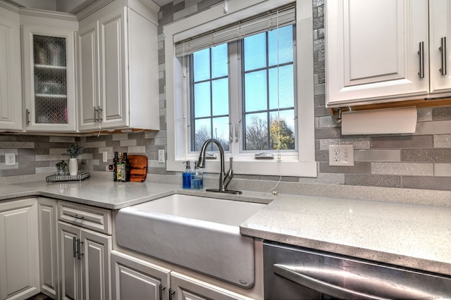 kitchen featuring white cabinets, dishwasher, sink, and tasteful backsplash