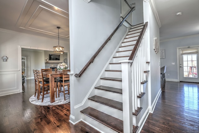 staircase with wood-type flooring and crown molding