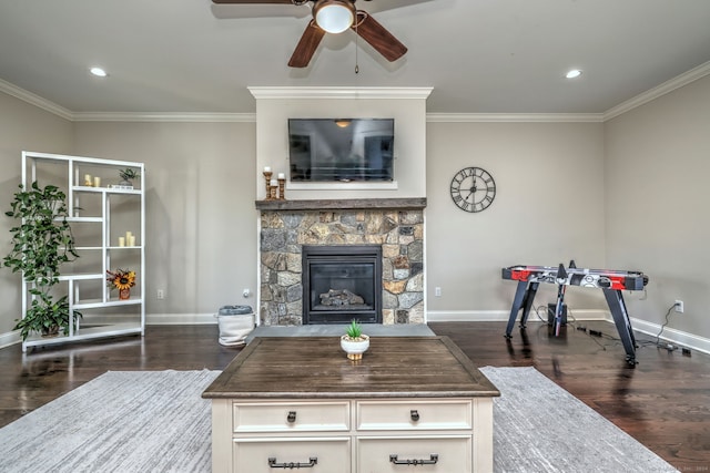 living room featuring ceiling fan, dark hardwood / wood-style flooring, ornamental molding, and a fireplace