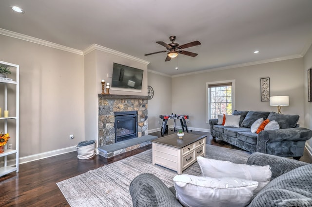 living room featuring a stone fireplace, crown molding, ceiling fan, and dark wood-type flooring