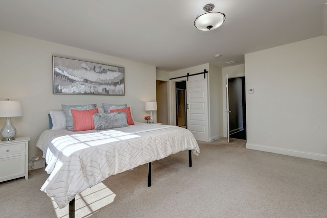 bedroom featuring a barn door and light colored carpet