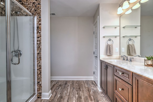 bathroom featuring hardwood / wood-style flooring, vanity, and a shower with door