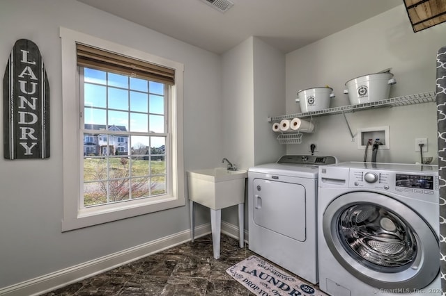 laundry room featuring washing machine and dryer and a healthy amount of sunlight