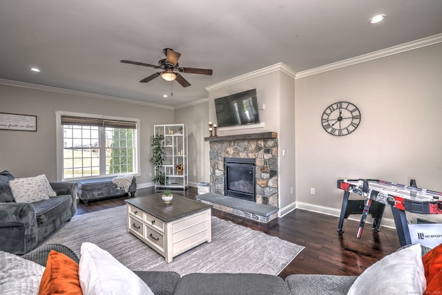 living room featuring crown molding, a fireplace, ceiling fan, and dark hardwood / wood-style floors