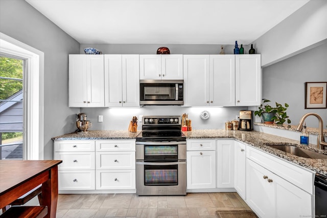 kitchen featuring white cabinets, plenty of natural light, sink, and stainless steel appliances