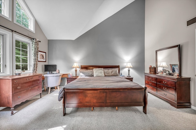 carpeted bedroom with high vaulted ceiling