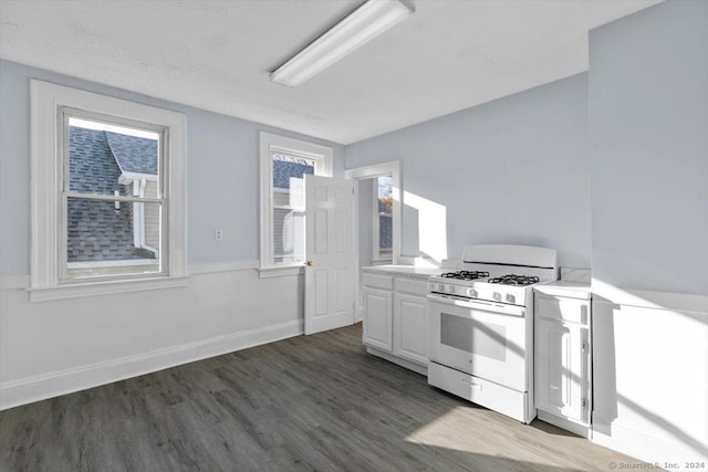 kitchen featuring white cabinetry, white gas range, and dark hardwood / wood-style floors