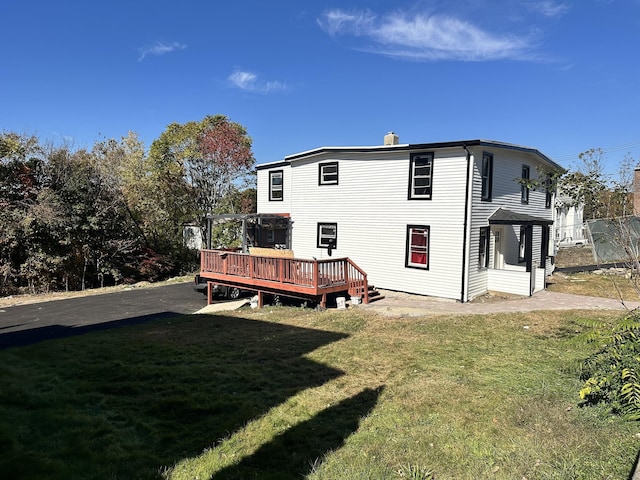 rear view of property with a lawn and a deck