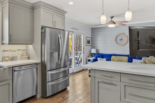 kitchen with appliances with stainless steel finishes, ceiling fan, dark wood-type flooring, pendant lighting, and gray cabinets