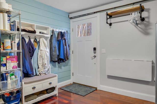 mudroom with wood walls and dark wood-type flooring