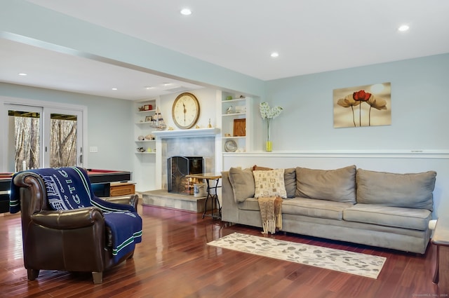 living room featuring dark hardwood / wood-style floors and a tiled fireplace