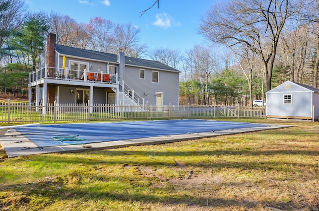 exterior space featuring a yard, a storage unit, and a pool side deck