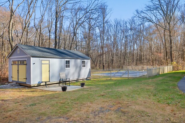 view of yard featuring a swimming pool and an outdoor structure