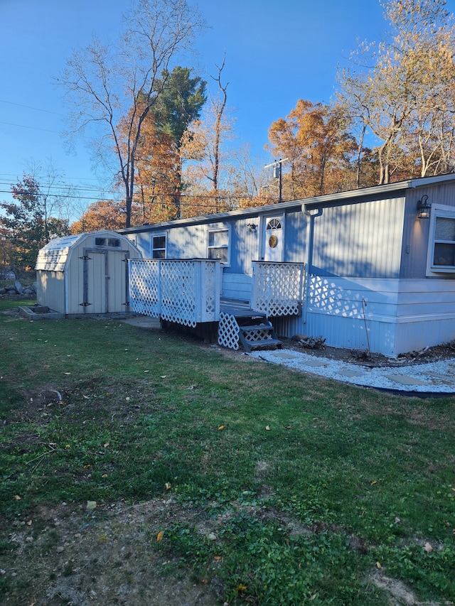 back of house featuring a lawn and a storage unit