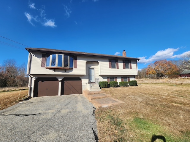 bi-level home with a garage and a front lawn