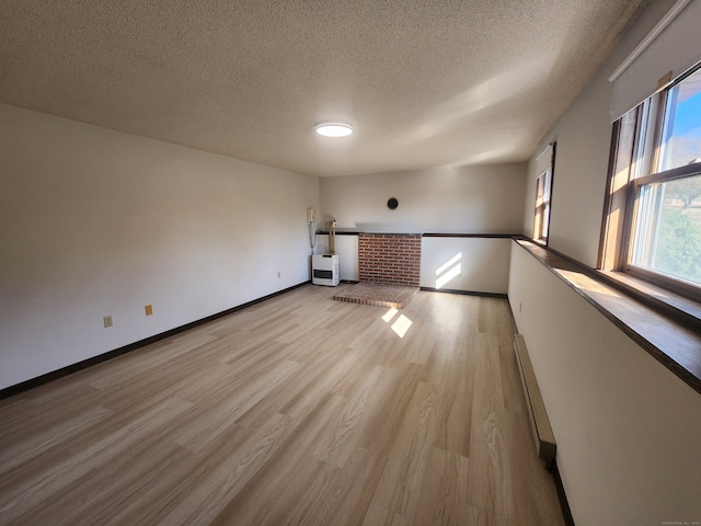 empty room featuring light wood-type flooring and a textured ceiling