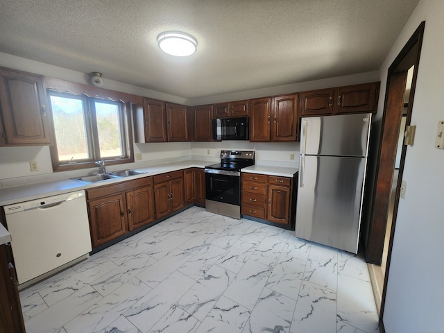 kitchen featuring a textured ceiling, sink, and appliances with stainless steel finishes