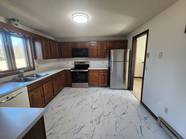 kitchen featuring appliances with stainless steel finishes, a textured ceiling, dark brown cabinetry, sink, and baseboard heating