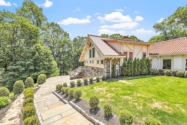 7 Topping Ln, Norwalk, CT 06854 - view of front of house featuring a front lawn, stucco siding, and a tiled roof