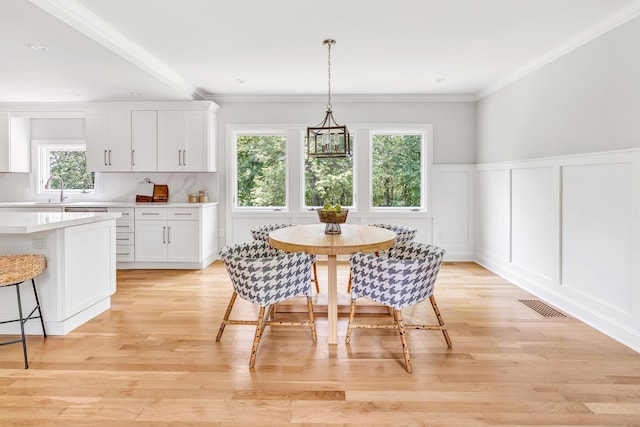 7 Topping Ln, Norwalk, CT 06854 - dining space with plenty of natural light, a decorative wall, crown molding, light wood-style flooring, and a wainscoted wall