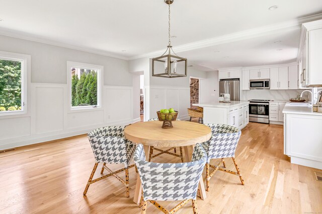 7 Topping Ln, Norwalk, CT 06854 - dining room with a wainscoted wall, light wood-style floors, crown molding, and a decorative wall