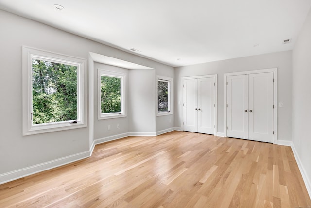 7 Topping Ln, Norwalk, CT 06854 - unfurnished bedroom featuring two closets, baseboards, and light wood-type flooring