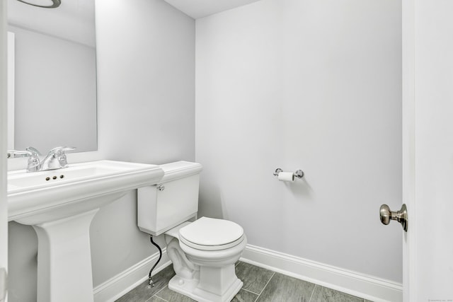 7 Topping Ln, Norwalk, CT 06854 - bathroom with toilet, baseboards, wood finished floors, and a sink