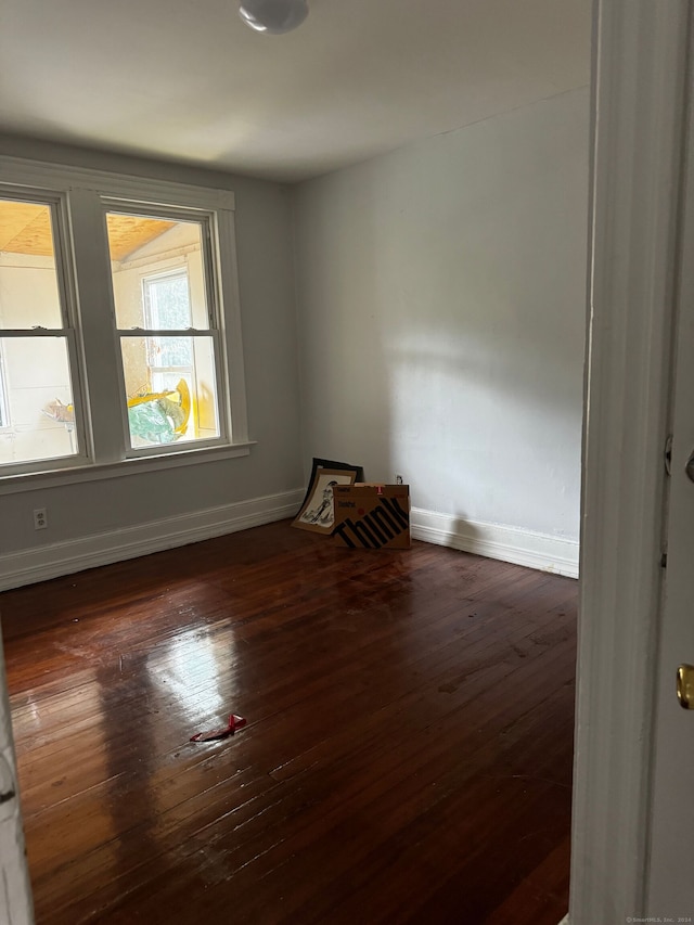 empty room with dark hardwood / wood-style flooring