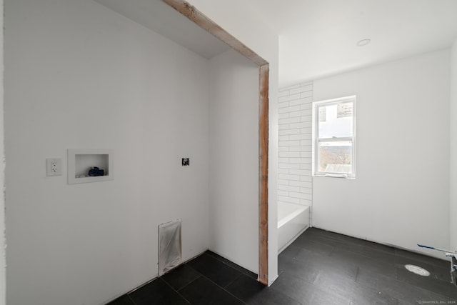 washroom with washer hookup and dark tile patterned flooring