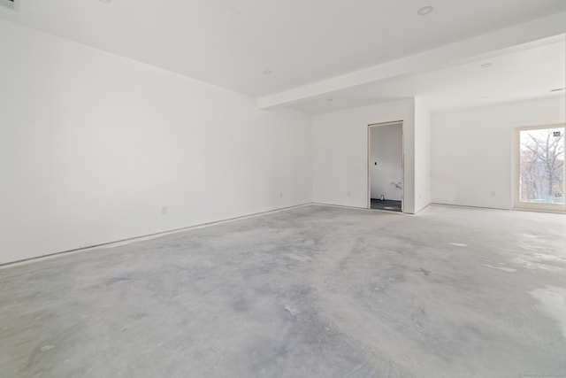 unfurnished room featuring beam ceiling