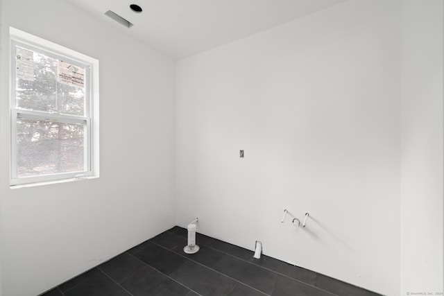 laundry room with dark tile patterned flooring