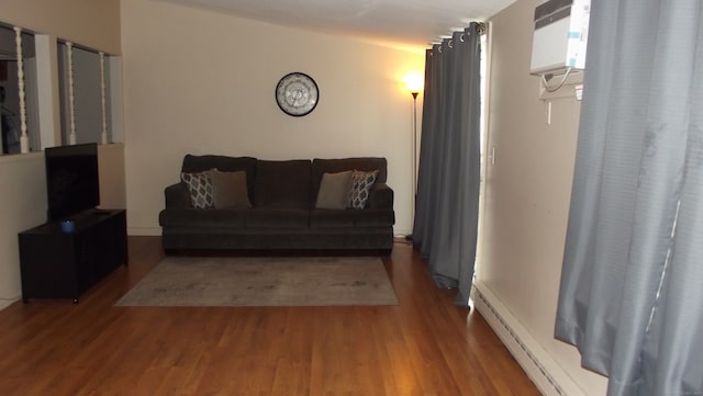 living room with hardwood / wood-style flooring, a wall mounted AC, and a baseboard heating unit