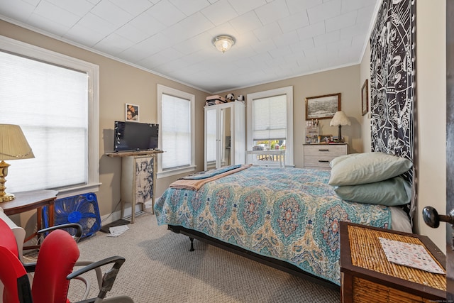 bedroom featuring multiple windows, crown molding, and carpet